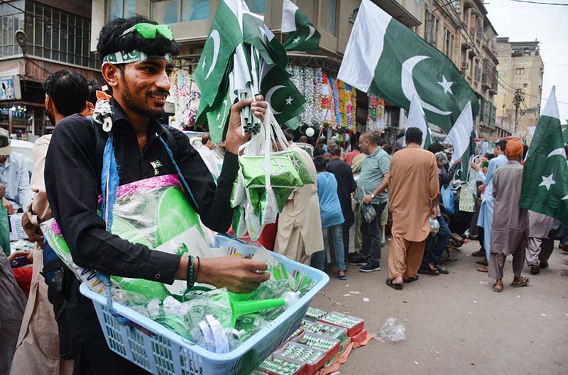 A vendor is selling National flags and badges at Paper Market in connection with of Independence Day