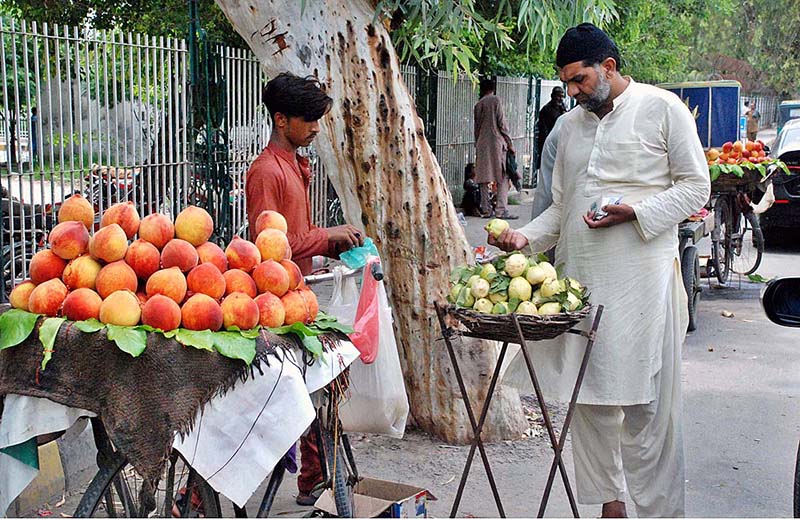 A man buys guavas outside the Victoria Hospital