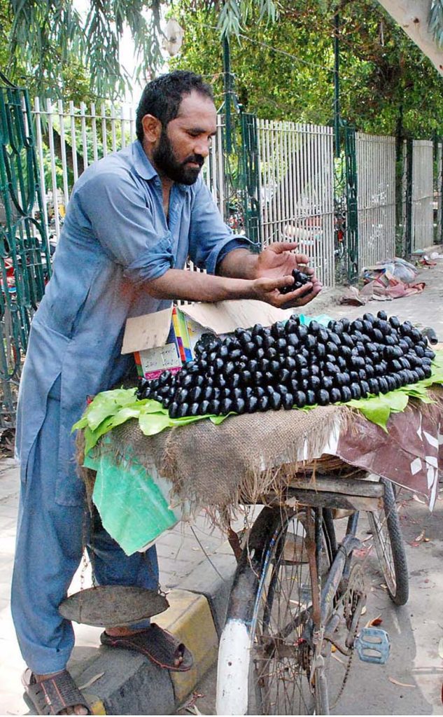 A man buys guavas outside the Victoria Hospital