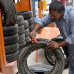 A worker polishing old tires at his work place