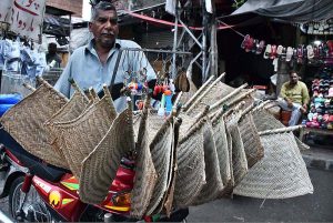 A vendor displaying the handmade hand fans on his motorcycle for customers while shuttling