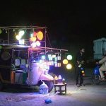 A young man selling beautiful fancy bright decorated lightning lamps on his rickshaw