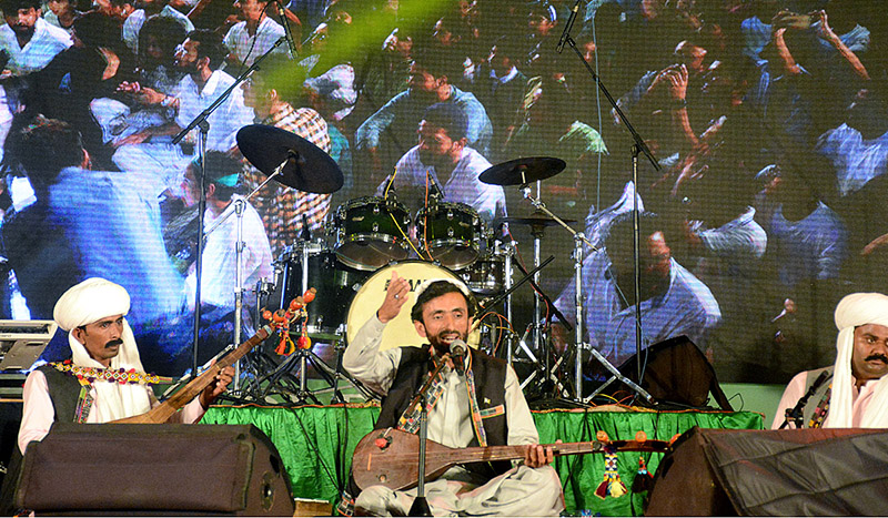 Girls dressed in green and white suits are enthusiastically celebrating at the Azadi Festival hosted at the Arts Council of Pakistan