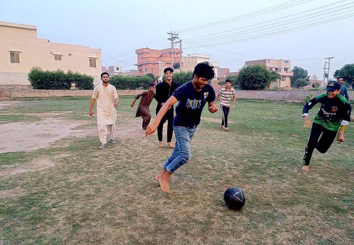 Youngsters are playing football in a local ground