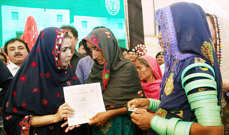 Federal Minister for Poverty Alleviation and Social Safety & Chairperson, Benazir Income Support Programme Ms. Shazia Marri distributing ownership (Sanad) of houses built by Sindh Government to the deserving people during the ceremony “Distribution of Land Title to Flood Affectees