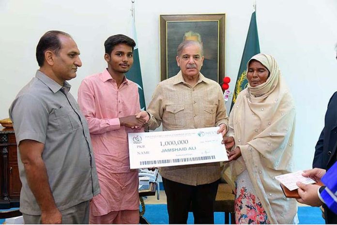 Prime Minister Muhammad Shehbaz Sharif presenting a cheque of 1 million rupees to Jamshed Ali in recognition of his exceptional performance by securing the first position in Matriculation Examination 2023 in Gujranwala Board