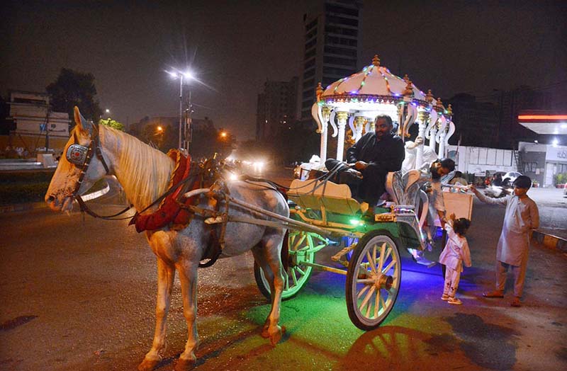 A family enjoying ride in decorated victoria horse cart.