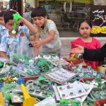 Children selecting decorative items in connection with Pakistan Independence Day celebrations at Kutchehry Bazar