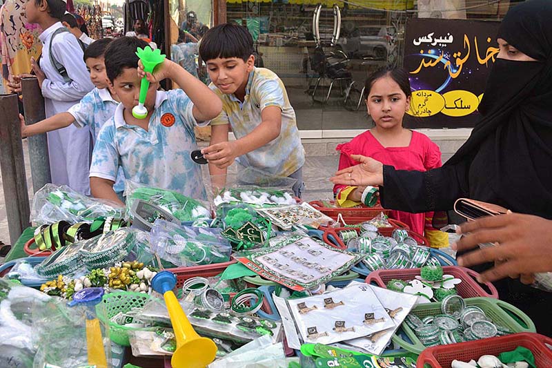Children selecting decorative items in connection with Pakistan Independence Day celebrations at Kutchehry Bazar