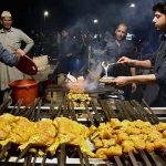 A vendor busy in preparing traditional (Bar-BQ) to the customers on the roadside setup at outside the Railway Station