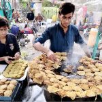 Vendor is preparing traditional food item for customers at his roadside setup