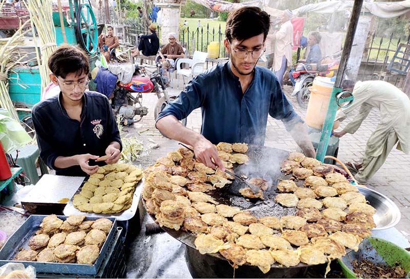 Vendor is preparing traditional food item for customers at his roadside setup