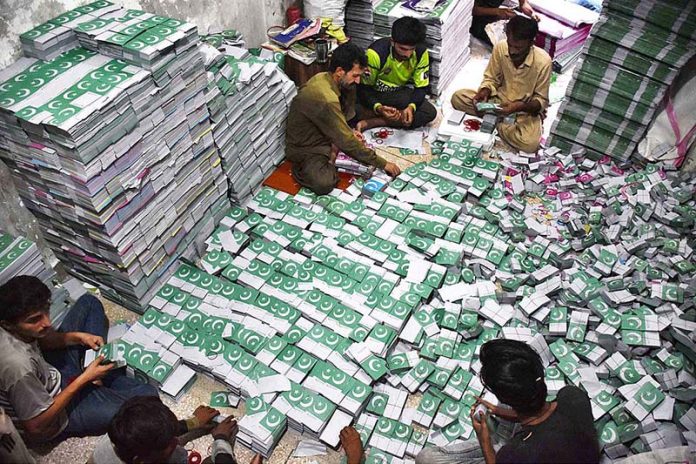 Workers tying and packing bundles of bunting Pakistani flags after printing to be used in preparations for the upcoming celebration of Independence Day across the country Workers tying and packing bundles of bunting Pakistani flags after printing to be used in preparations for the upcoming celebration of Independence Day across the country