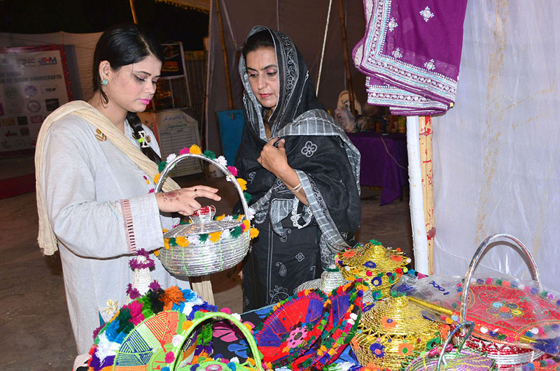 Visitors viewing traditional handmade stuff on the stall during an exhibition of Sindh handicraft at Old Campus