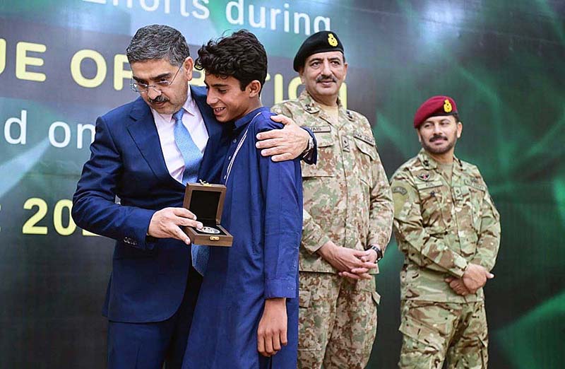 Caretaker Prime Minister Anwaar-ul-Haq Kakar distributing awards among the survivors of Battagram chairlift incident for their bravery at a ceremony.