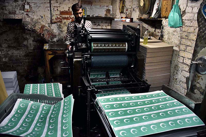 Workers tying and packing bundles of bunting Pakistani flags after printing to be used in preparations for the upcoming celebration of Independence Day across the country