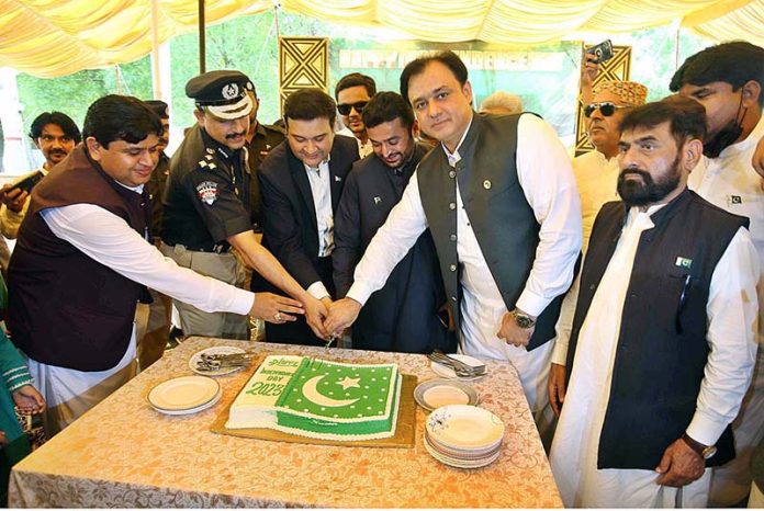 Commissioner Bilal Ahmed Memon along with DIG Pir Muhammad Shah and Mayer Kashif Shoro is cutting the cake during Flag hoisting ceremony at Circuit House on the occasion of 77th Independence Day celebration