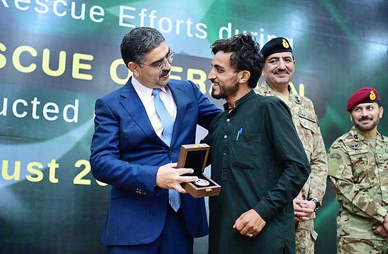 Caretaker Prime Minister Anwaar-ul-Haq Kakar distributing awards among the survivors of Battagram chairlift incident for their bravery at a ceremony