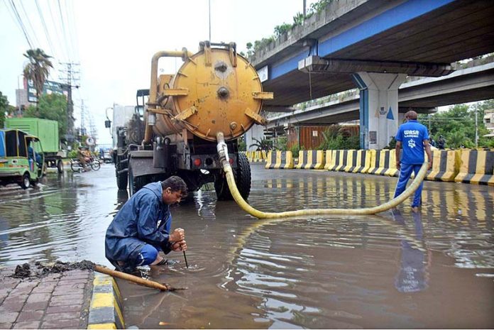 WASA staff working to restore the sewerage system near Kalma Chowk