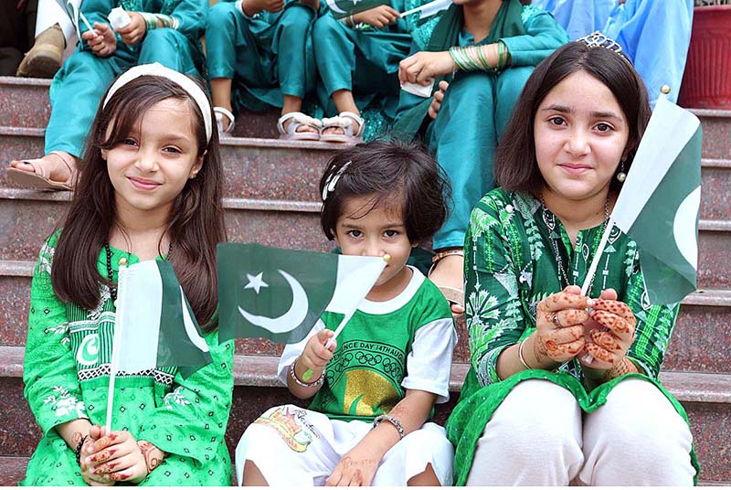 Children, dressed in flag-colored clothing and holding Pakistani flag during Flag hoisting ceremony at Rescue 1122 Headquarter on the occasion of 77th Independence Day celebration