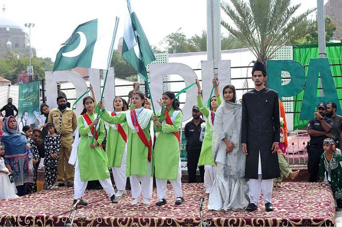 Students performing tableau during a ceremony organized by the City District Government at Ghanta Ghar on the occasion of 77th Independence Day celebration
