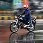 Motorcyclist on the way during heavy rain in the Provincial Capital