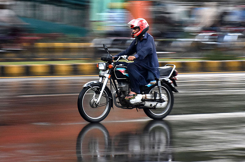 Motorcyclist on the way during heavy rain in the Provincial Capital