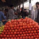 People purchasing vegetables from a stall at Sunday Bazar Peshawar Morr
