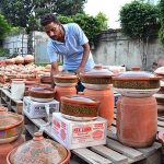 A vendor displaying clay made pots to attract customers at his roadside setup near Muslim Town market.