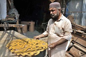A carpenter busy in preparing wooden item at his workplace in Federal Capital.