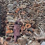 Old man cutting wood into pieces for selling purpose at his workplace in the Federal Capital.