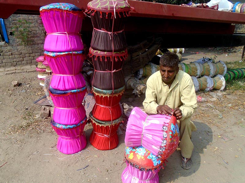 A worker busy in making traditional chair (moorah) at his workplace near Sargodha road