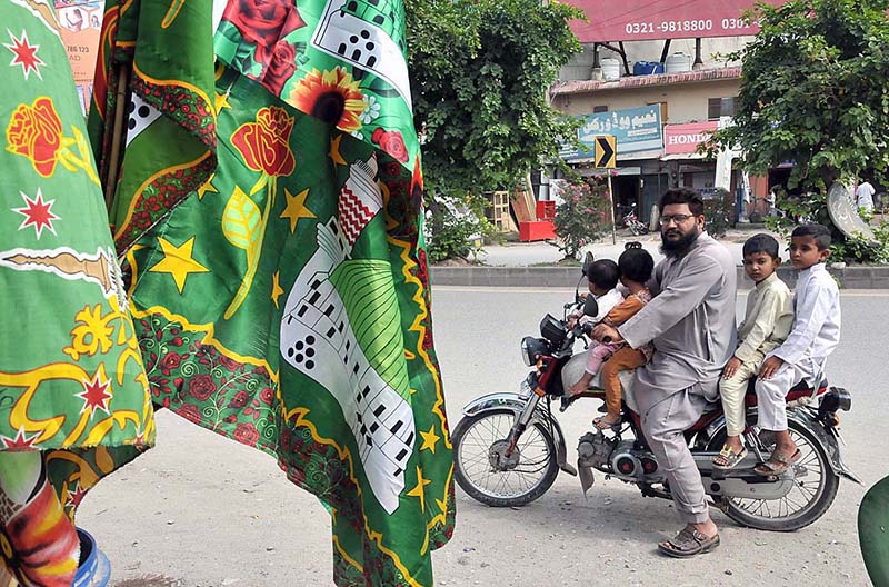 A family on motorbike saw Eid Milad-un-Nabi related stuff for selling at roadside in the Federal Capital
