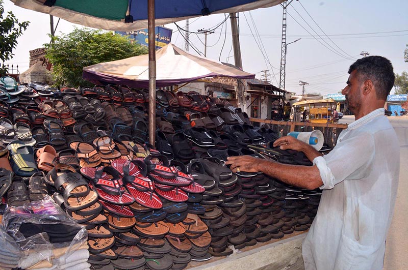 A vendor selling shoes on his roadside setup at City road