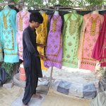 Roadside vendors displaying the ladies suits to attraction the customers at Tando Yosuf Road.