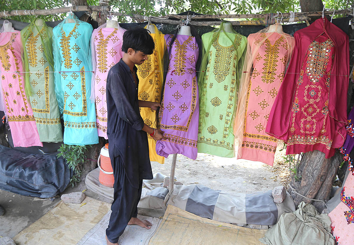 Roadside vendors displaying the ladies suits to attraction the customers at Tando Yosuf Road.
