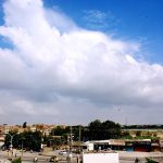 A beautiful view clouds hovering over the sky in the city.