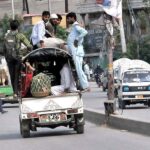 People sitting and hanging on the roof top of Pick up van in a dangerous way may cause any mishap and need attention of concerned authorities