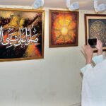 Female visitor capture painting in mobile during Quranic calligraphy exhibition at Arts Council.