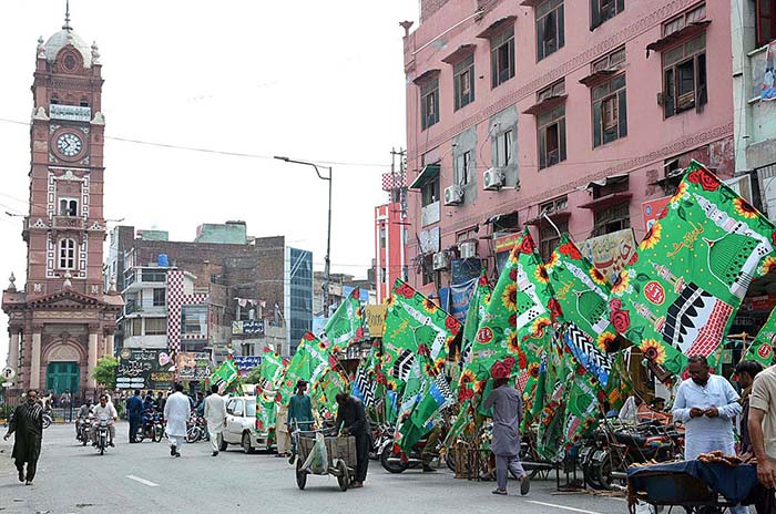 Shopkeepers displayed green flags outside their shops at Amin Pur Bazaar to attract the customers in connection with Eid Milad-un-Nabi (PBUH).