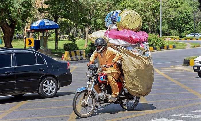 A motorcyclist on the way loaded with valuables after collecting from different points in Federal Capital.