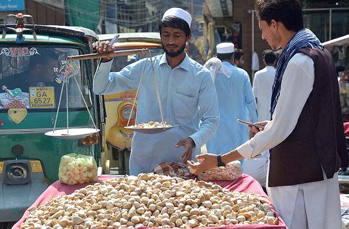 Vendor selling and displaying garlic on his handcart at Hashtnagri Chowk.