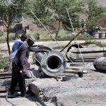 Labourers are busy preparing sewage pipes at their workplace