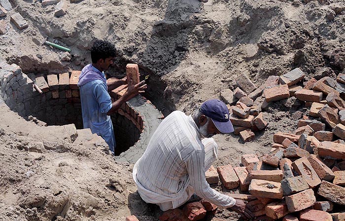 Labourers are preparing the sewage manhole at the Head Muhammad Wala Road