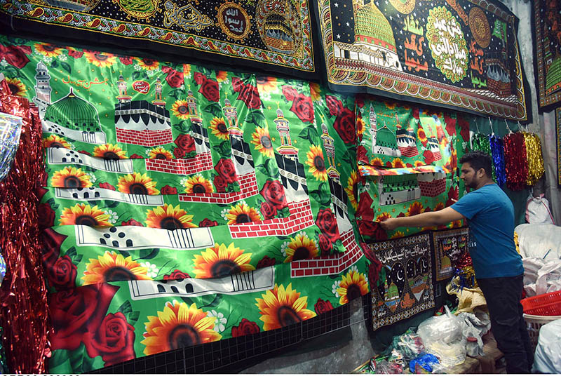 A vendor arranging and displaying Eid Milad-un-Nabi (PBUH) related stuff to attract the customersat his shop