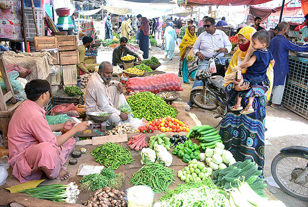 People selecting and purchasing different vegetables from vendor at Latifabad
