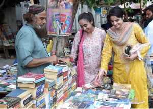 Women selecting old books on a roadside stall in the Provincial Capital