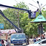 Cantonment worker busy in repairing street lights of pole at Pakistan chowk.