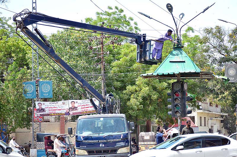 Cantonment worker busy in repairing street lights of pole at Pakistan chowk.