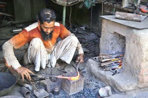An artisan preparing iron tools at his workplace. 